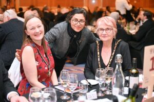 Hillingdon Business Awards 2025. The Mayor of Hillingdon posing with two other women at their table. All are smiling.